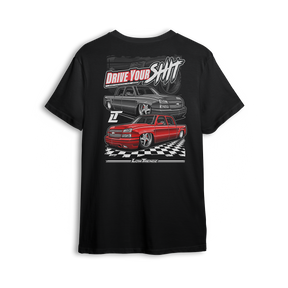 T-shirt featuring two slammed Silverados rolling on a checkered track floor with bold red-and-black styling. The “Just Drive Your Sh*t” t-shirt calls out real show truck owners who drive what they build—no trailers, no excuses.