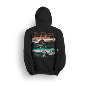 Hoodie featuring two slammed Chevy C10s in orange/white and mint/white two-tone colorways, laid out over a modern grid with layered Low Trendz branding. The Two-Tone Throwback hoodie blends vintage Chevy style with a clean, show-ready stance.