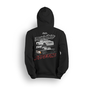 Hoodie featuring a slammed silver C10 and murdered-out OBS truck in a bold drag-ready layout with burnout marks and street-style font. The Running the Streets hoodie captures boosted attitude, full-send energy, and late-night racing vibes.