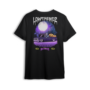 Halloween t-shirt featuring a slammed Squarebody in a graveyard at night with a full moon and skeleton behind the wheel